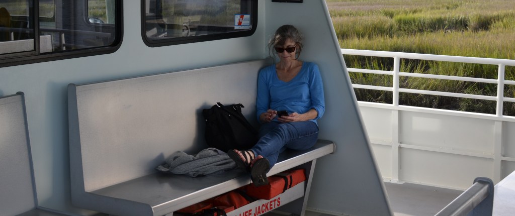 A picture of Dr. Moran sitting on a bench on a boat.